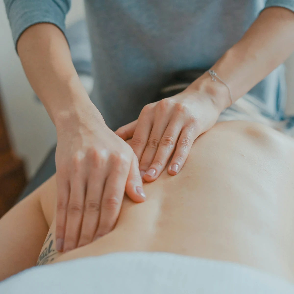 A person laying down receiving a massage.
